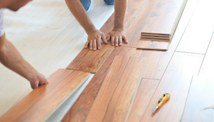 People installing an Invicible Hardwood floor planks 